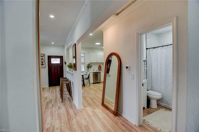 corridor featuring crown molding and light hardwood / wood-style flooring