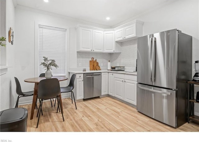 kitchen with tasteful backsplash, light hardwood / wood-style floors, stainless steel appliances, and white cabinetry