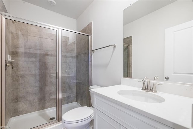 bathroom with a shower with door, vanity, and toilet