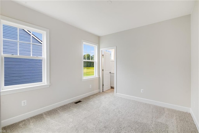 spare room featuring light colored carpet