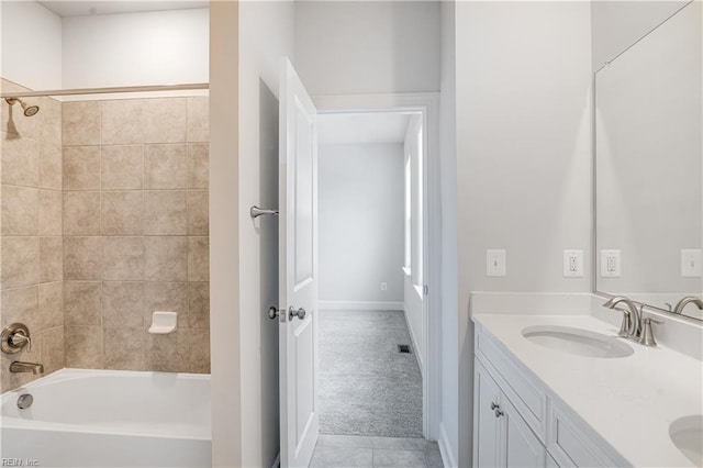 bathroom with tiled shower / bath combo and vanity