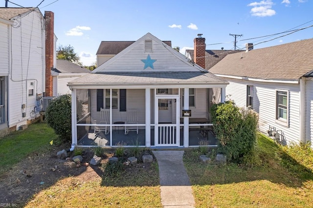 view of front facade featuring a front yard and a sunroom