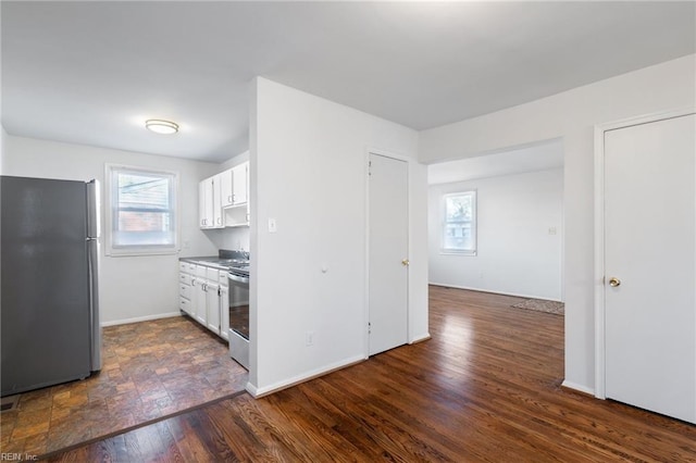 kitchen featuring stainless steel appliances, dark hardwood / wood-style flooring, and white cabinetry