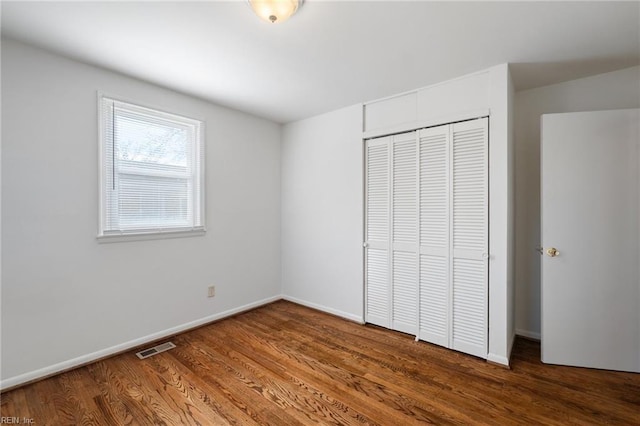 unfurnished bedroom featuring a closet and hardwood / wood-style floors