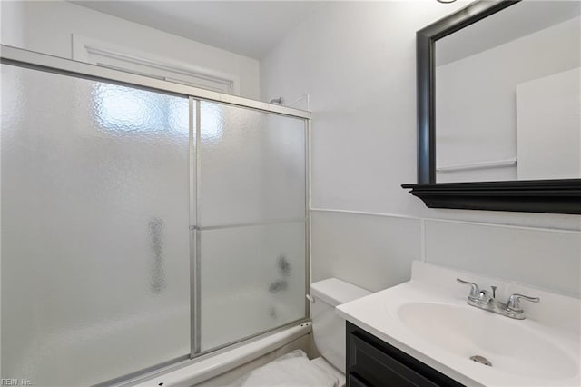 full bathroom featuring toilet, shower / bath combination with glass door, and vanity