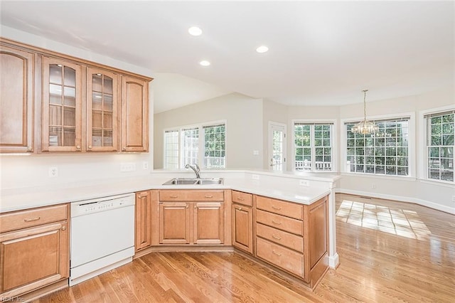 kitchen with sink, dishwasher, light wood-type flooring, hanging light fixtures, and a chandelier