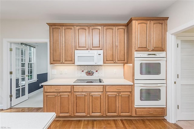 kitchen with white appliances and light wood-type flooring