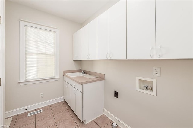 washroom with cabinets, light tile patterned floors, washer hookup, electric dryer hookup, and sink