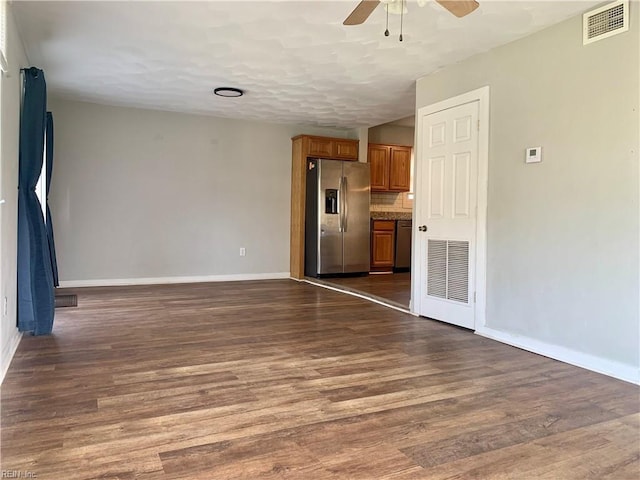 unfurnished living room featuring dark wood-type flooring and ceiling fan