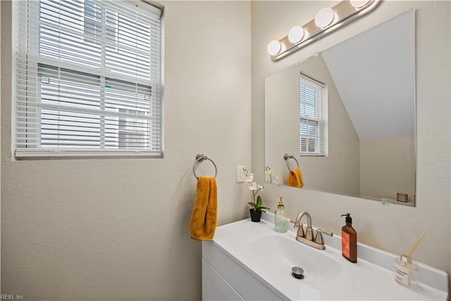 bathroom with vaulted ceiling and vanity