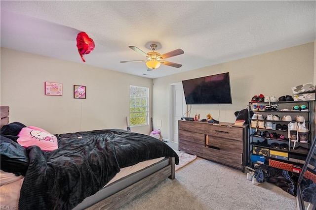 bedroom with a textured ceiling, ceiling fan, and light colored carpet