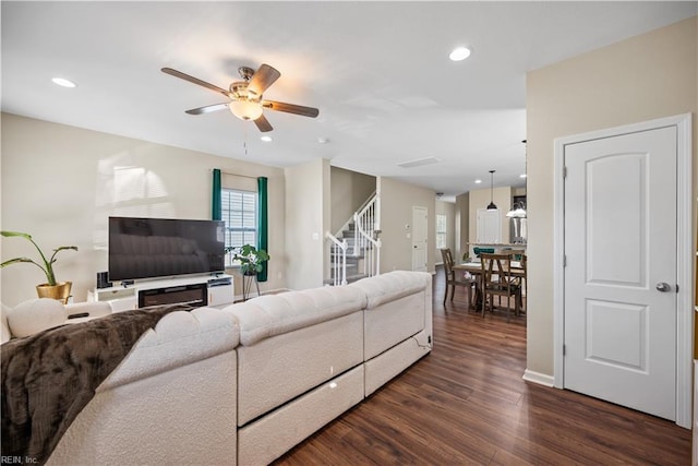 living room with dark hardwood / wood-style flooring and ceiling fan