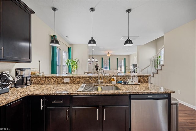 kitchen with light stone countertops, stainless steel dishwasher, dark hardwood / wood-style flooring, dark brown cabinets, and sink