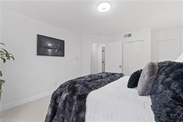 carpeted bedroom featuring a textured ceiling and a closet