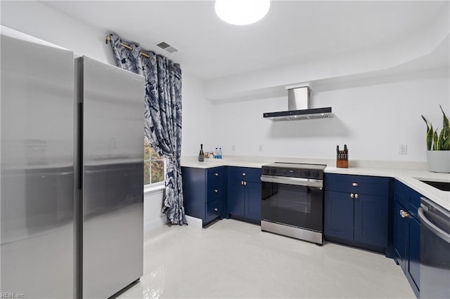 kitchen with blue cabinets, wall chimney range hood, and appliances with stainless steel finishes