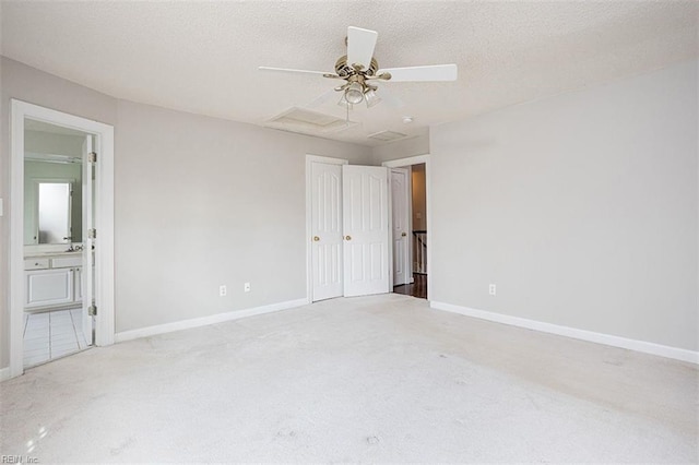 empty room with a textured ceiling, ceiling fan, and light carpet