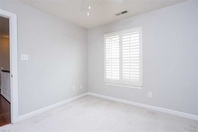 carpeted empty room with a textured ceiling