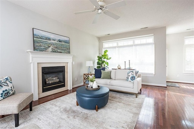 living room with ceiling fan, a textured ceiling, and wood-type flooring