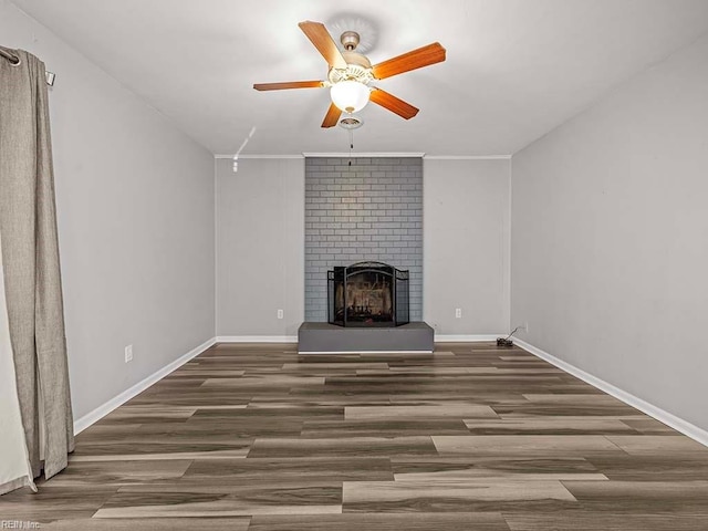 unfurnished living room featuring dark wood-type flooring and a brick fireplace