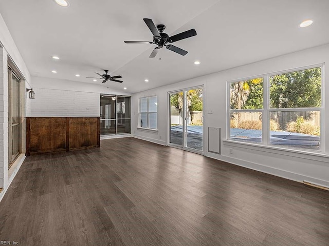 unfurnished living room with dark hardwood / wood-style flooring, ceiling fan, and a wealth of natural light