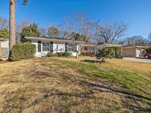 single story home featuring a front lawn and a garage