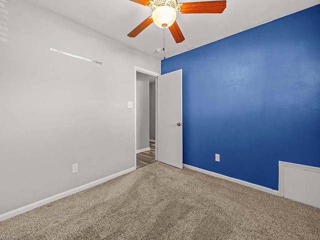 carpeted spare room with ceiling fan