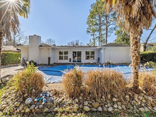 back of property with a covered pool