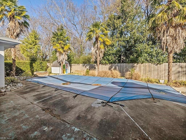 view of swimming pool with a storage unit and a patio