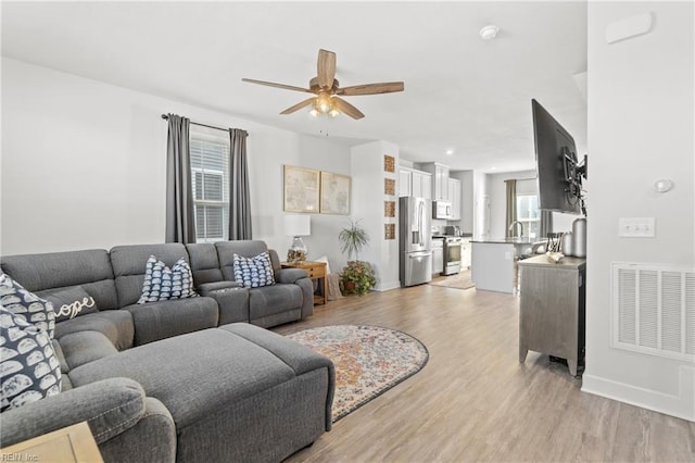 living room featuring ceiling fan and light wood-type flooring