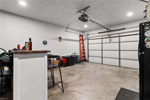 garage featuring a garage door opener and black refrigerator