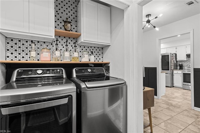 laundry area featuring cabinets, separate washer and dryer, and light tile patterned floors