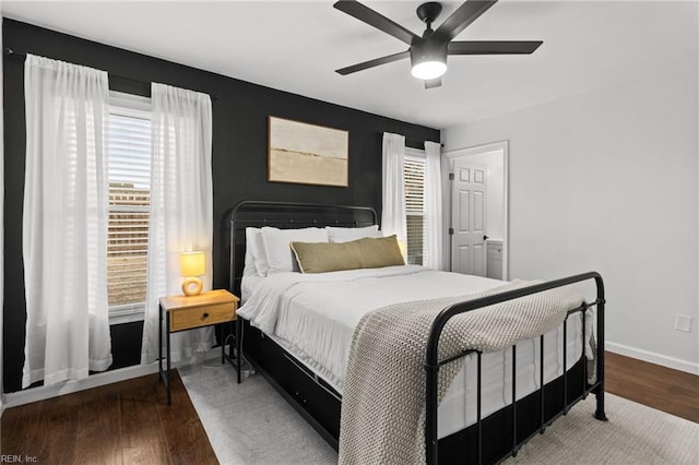 bedroom featuring ceiling fan, hardwood / wood-style floors, and multiple windows