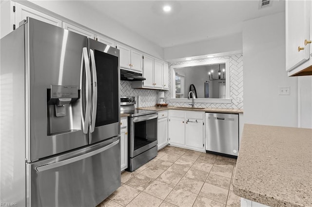 kitchen with ventilation hood, appliances with stainless steel finishes, white cabinets, and sink