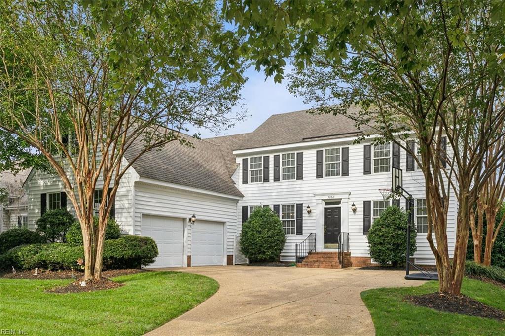 colonial home featuring a front lawn and a garage