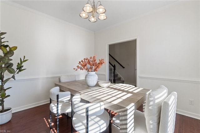 dining space featuring dark hardwood / wood-style flooring, ornamental molding, and a chandelier