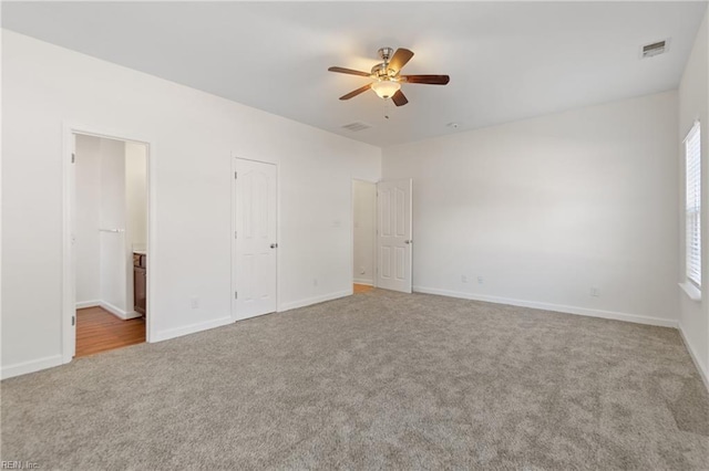 unfurnished bedroom featuring carpet floors, ceiling fan, and connected bathroom