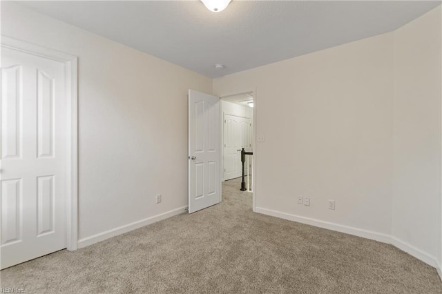 unfurnished room featuring light carpet