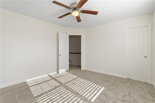 empty room with light colored carpet and ceiling fan