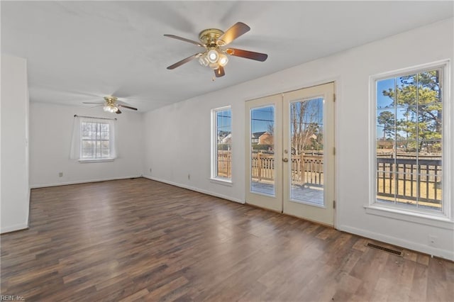 spare room with dark hardwood / wood-style flooring, ceiling fan, french doors, and a wealth of natural light