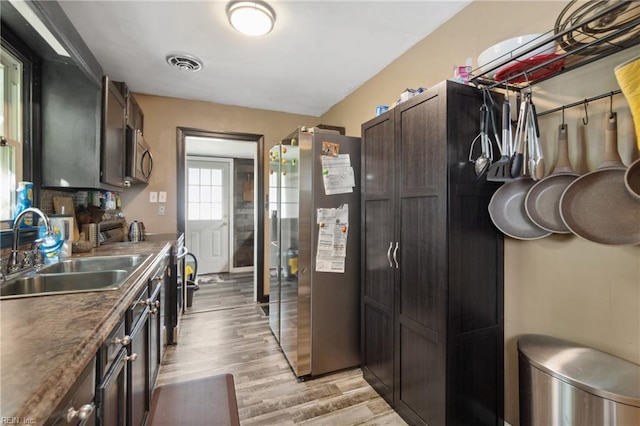 kitchen featuring stainless steel appliances, light hardwood / wood-style flooring, dark brown cabinets, and sink