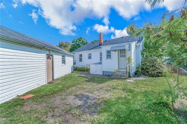 rear view of property with a lawn