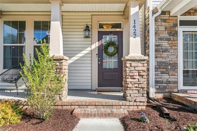 view of exterior entry featuring covered porch