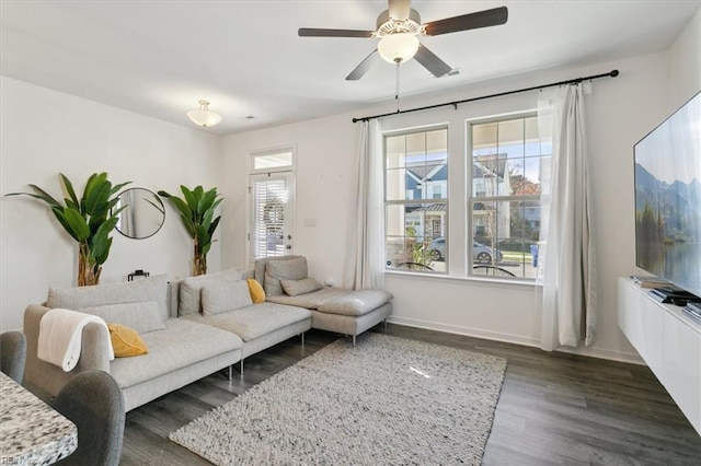 living room featuring ceiling fan and dark hardwood / wood-style floors