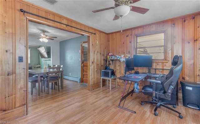 office area with ceiling fan, baseboard heating, light hardwood / wood-style floors, and wooden walls