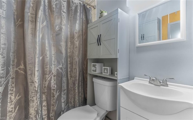 bathroom featuring a shower with shower curtain, vanity, and toilet