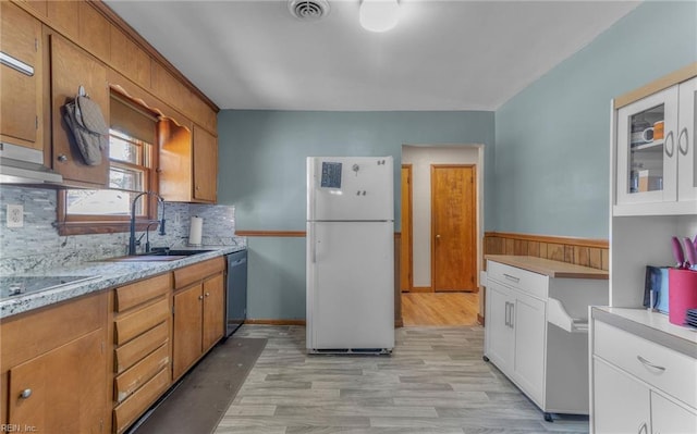 kitchen with dishwasher, white fridge, black electric cooktop, white cabinetry, and sink