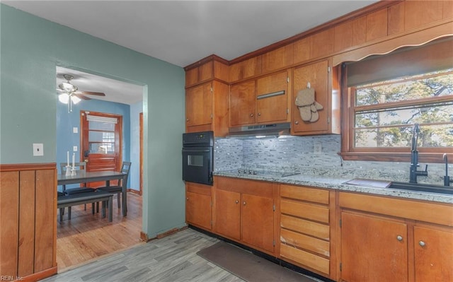 kitchen featuring sink, ceiling fan, light hardwood / wood-style floors, decorative backsplash, and black appliances