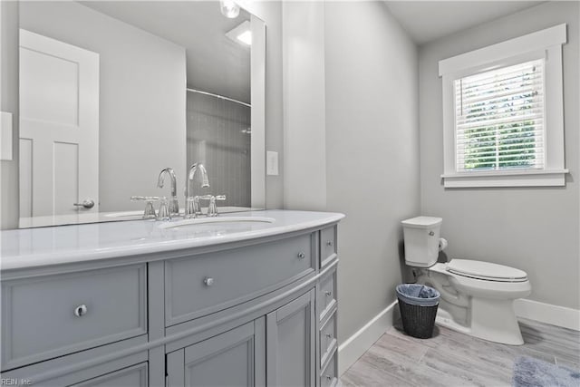 bathroom with toilet, a shower, and vanity