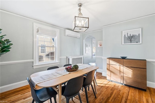 dining area featuring light hardwood / wood-style flooring, an inviting chandelier, and a wall unit AC