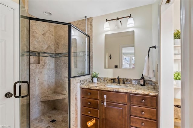 bathroom with a shower with shower door and vanity